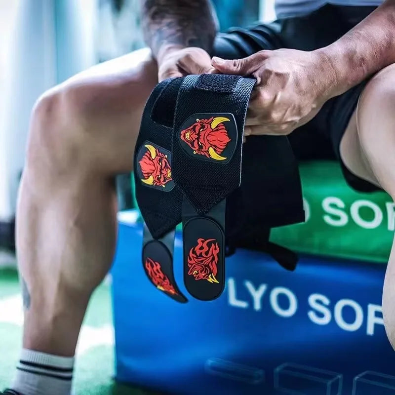 Une main tient des bandes de poignet de gym noires avec des motifs de dragons rouges et jaunes.