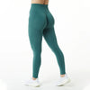 Une personne portant des leggings de yoga sans couture taille haute bleu sarcelle, debout et regardant vers le bas.