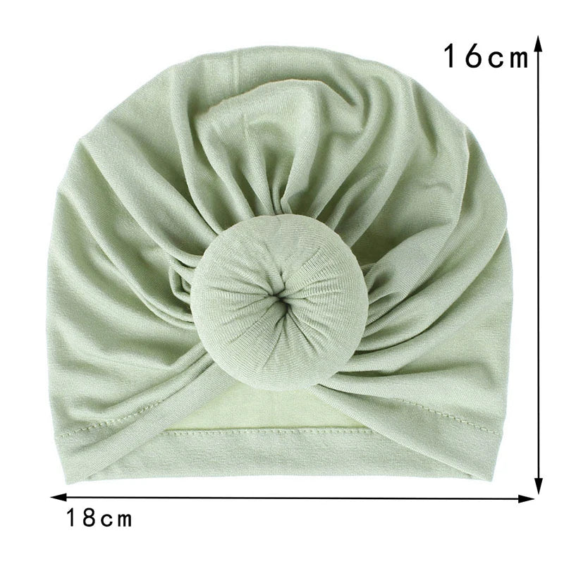 Helles grünes, solides Baumwoll-Baby-Turban-Tuch in gefalteter Wickelform.