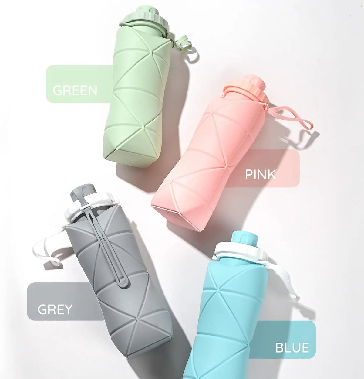 A collection of four collapsible silicone sports water bottles in green, pink, grey, and blue are displayed on a white backgr