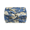 A blue fabric headband with a floral print featuring beige and white roses and leaves.