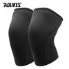 A pair of black knee sleeves designed for weightlifting and squats.