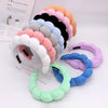 A display of colorful sponge terry cloth headbands for hair styling in various shades of pink, purple, blue, and gray.