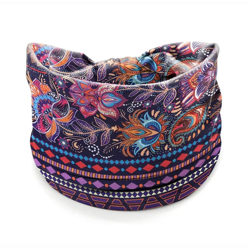 A close-up of a bohemian stretch cotton headband featuring a dark blue background with colorful floral and paisley patterns.
