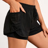 A woman wearing black athletic shorts with mesh pockets, showing the side pocket detail.