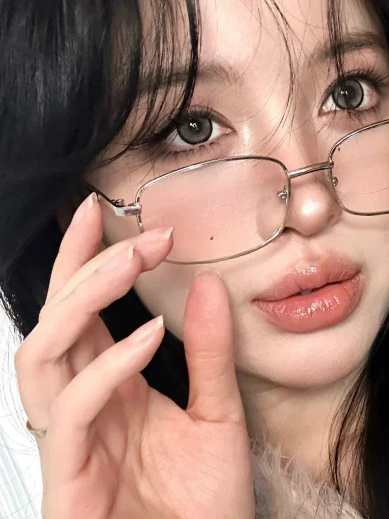 Close-up photo of a woman wearing retro square frame eyeglasses