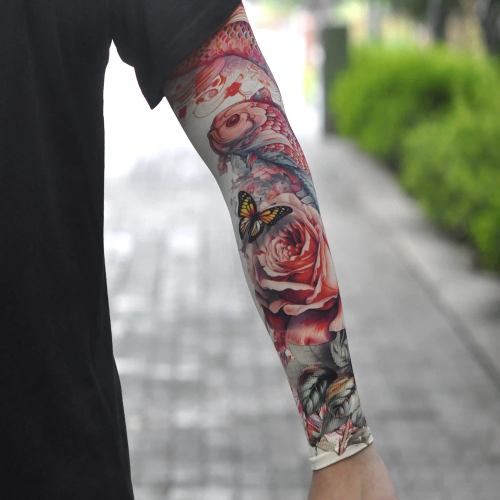 A close-up of a person's arm displaying colorful floral and butterfly tattoo sleeve art.