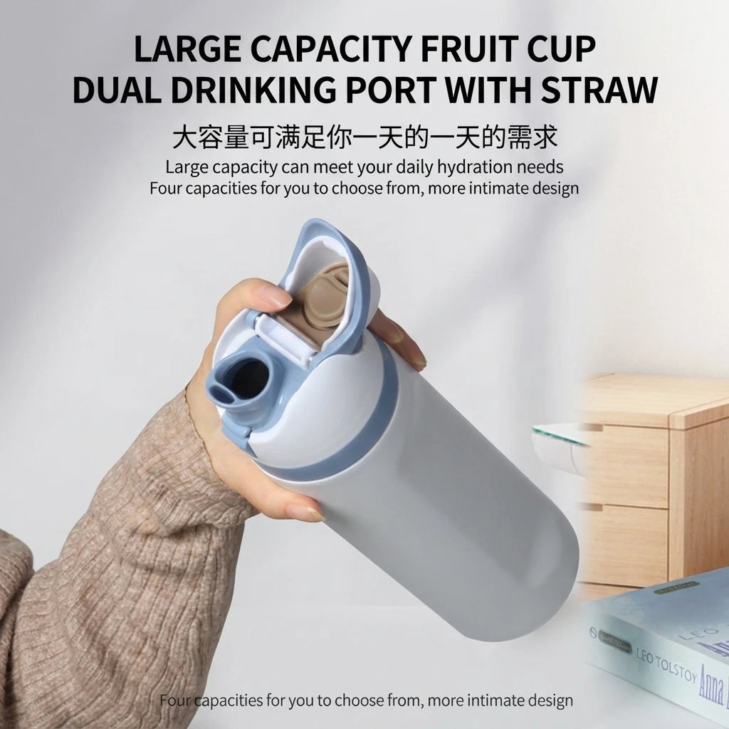 A hand holds a large capacity dual drinking port fruit cup water bottle with a straw.