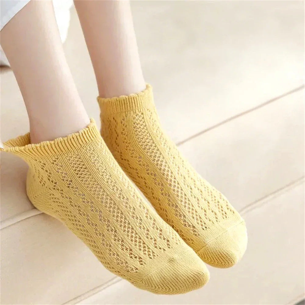 A pair of yellow breathable mesh lace tube socks for women shown on a light background.