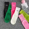 Eine Sammlung farbenfroher, atmungsaktiver, rutschfester Yoga- und Fitnesssocken in verschiedenen Farbtönen wie Schwarz, Grün