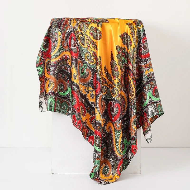 A vibrant silk paisley shawl scarf featuring intricate patterns in shades of red, orange, green, and black.