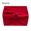 A vibrant red fabric headband is tightly cross-knotted and displayed flat.