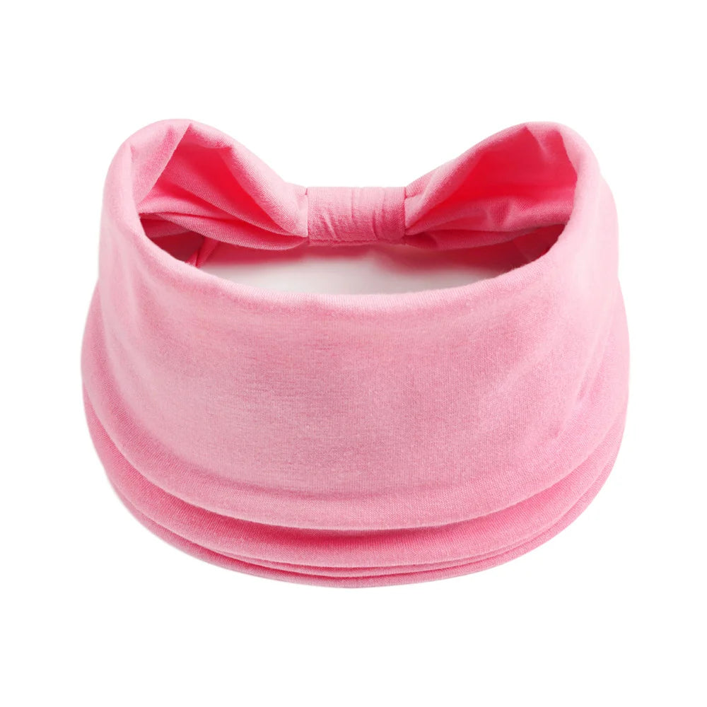 Foulard en coton rose froncé noué en nœud pour cheveux et style.