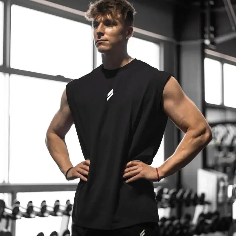 Muskulöser Mann in schwarzem ärmellosem Fitness-Top im Fitnessstudio.