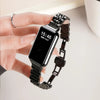 A hand is wearing a black smartwatch with a stainless steel mesh band displaying the time 15:46.