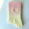 A pair of light pink and yellow ribbed socks with the 'dlo' logo on the toe area.