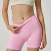 Un mannequin porte un short de yoga sans couture taille haute rose et un crop top crème.