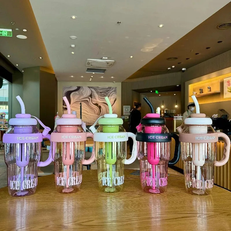 A row of colorful plastic sports water bottles with straws displayed on a wooden surface.