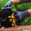 A hand wearing blue work gloves is operating a yellow power tool outdoors.
