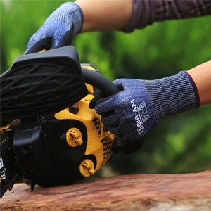 A hand wearing blue work gloves is operating a yellow power tool outdoors.
