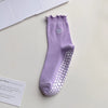 A purple yoga sock with a scalloped cuff and a heart embroidery on the toe area.
