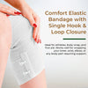A hand is applying a white elastic bandage with a single hook and loop closure to a person's knee area.