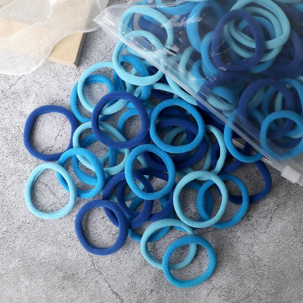 A pile of 50 pieces of mixed blue and cyan elastic hair bands in clear packaging.