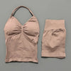A beige women's seamless fitness set consisting of a cropped top and matching shorts.