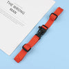 An orange adjustable tactical backpack strap harness is shown next to a piece of paper.