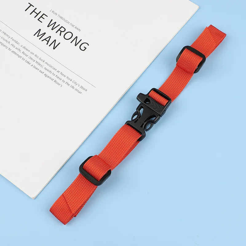 An orange adjustable tactical backpack strap harness is shown next to a piece of paper.