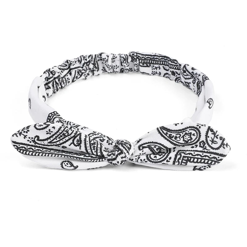 White and black paisley print elastic hair headbands tied in a bow