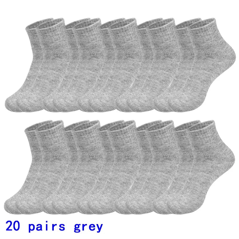 Ein Stapel von 20 Paar grauer, atmungsaktiver Baumwoll-Socken für Herren, flach ausgelegt.