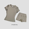 Un conjunto de dos prendas de yoga grises de talle alto para mujeres, incluyendo una camiseta y shorts.