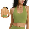 A woman wearing a olive green halter neck yoga and gym sports bra top.