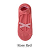 A pair of rose red yoga socks with a crisscross strap design.