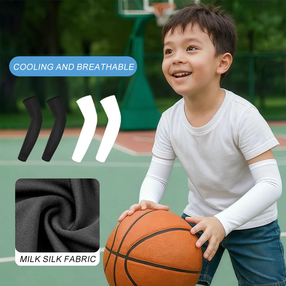 Ein junger Junge in weißer Sportkleidung und Kompressionsärmeln hält einen Basketball im Freien.