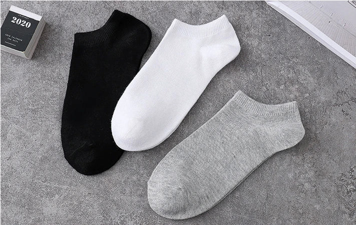 A display of three pairs of breathable men's sports ankle socks in black, white, and gray.
