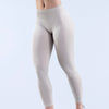 Modelo vistiendo leggings de yoga sin costuras de cintura alta en color gris claro.