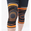 Black and orange breathable compression knee brace worn on a leg.