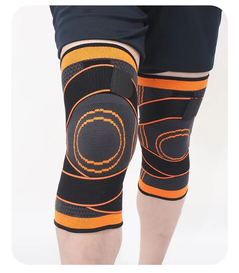 Black and orange breathable compression knee brace worn on a leg.