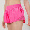 Pink women's high-waisted running shorts shown on a model.