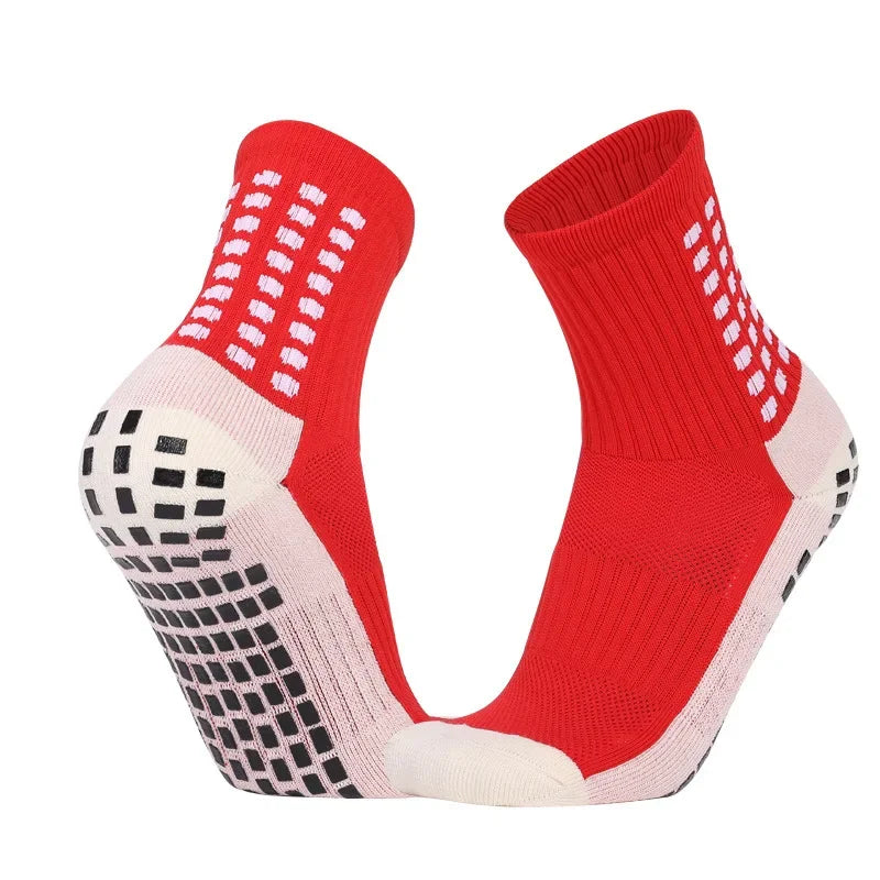 A pair of red performance sports grip socks with white accents, shown from the side.