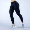 Eine Person trägt dunkelblaue, hoch taillierte, nahtlose Yoga-Leggings und weiße Sneaker.