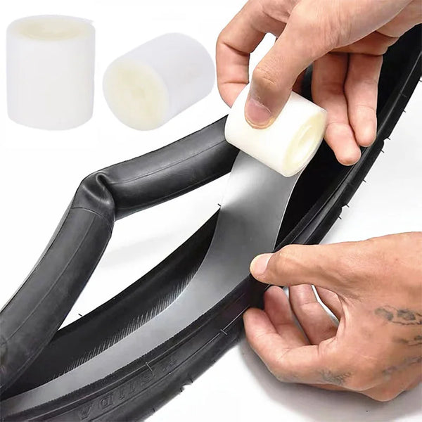 A hand is installing a bicycle puncture protection liner onto a tire rim.