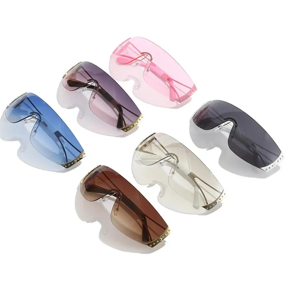 A collection of Y2K futuristic gradient sunglasses in pink, blue, and brown shades.