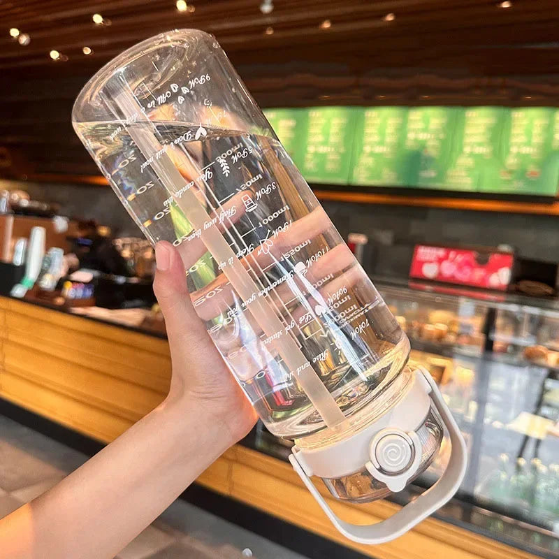 A hand holds a large capacity sport straw water bottle with a visible time scale, demonstrating its measurement features.