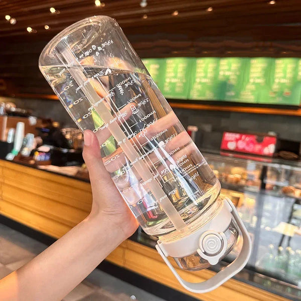 A hand holds a large capacity sport straw water bottle with a visible time scale, demonstrating its measurement features.