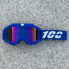 A pair of blue protective goggles with a white logo strap resting on a gray textured surface.