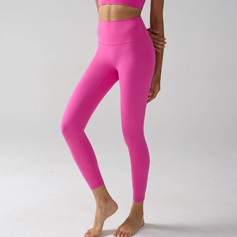 Un mannequin portant des leggings de performance rose vif à taille haute et un haut assorti court.