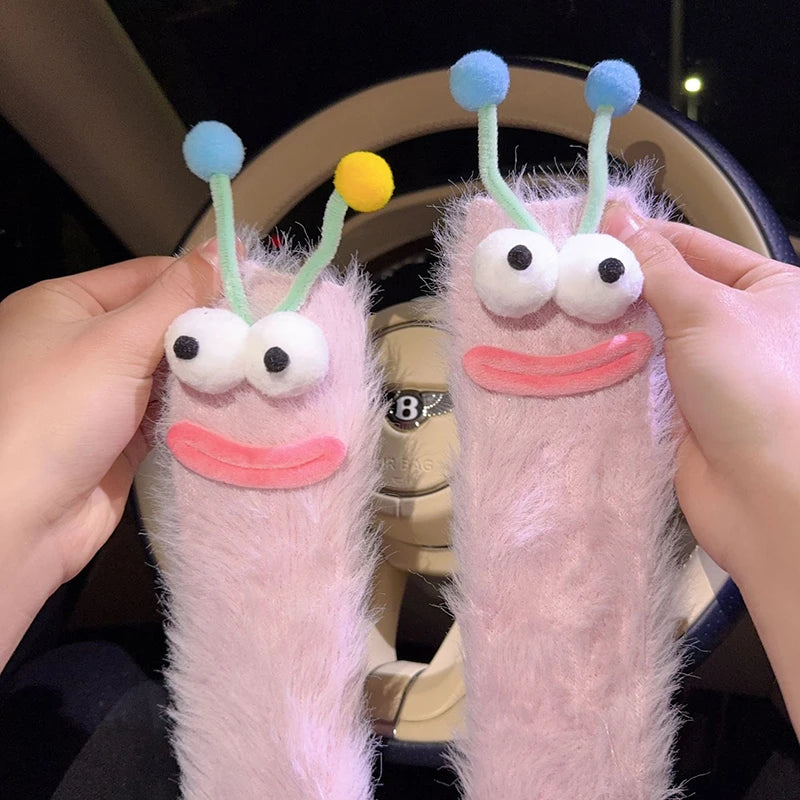 Pair of pink knit socks shaped like cartoon faces with blue and yellow ears